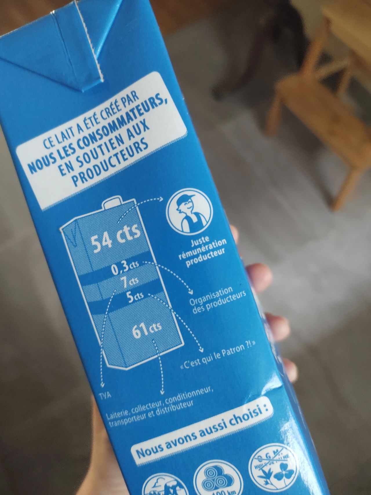 Photo of a blue carton of milk with a visualisation of all those involved in the production of the milk as if they made up the total volume of the carton. Annotations included to identify each party involved in production.
